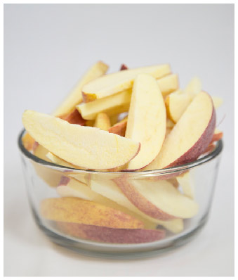 Freeze dried apple slices in a clear glass bowl